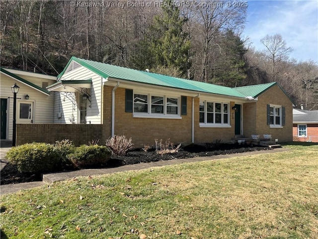 view of front of home with brick siding, metal roof, and a front lawn