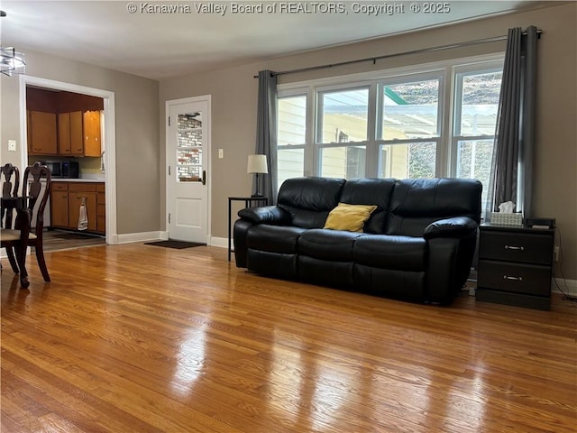 living area with baseboards and wood finished floors