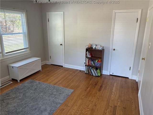 interior space with baseboards and wood finished floors