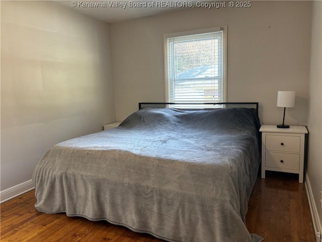 bedroom featuring wood finished floors and baseboards