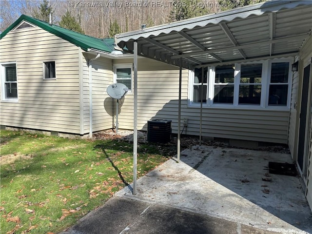 view of side of property featuring cooling unit, metal roof, a lawn, and a patio