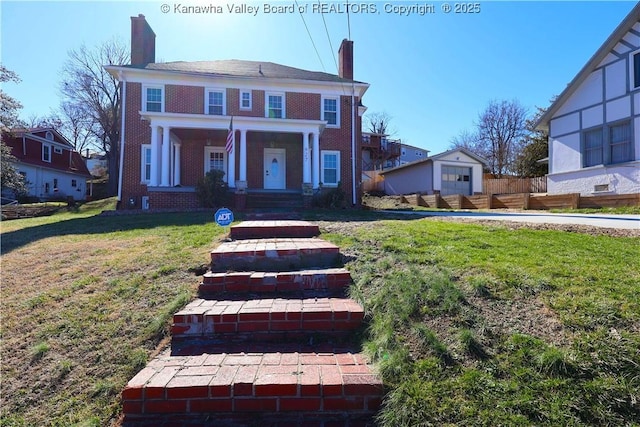 view of front of home with brick siding, fence, a chimney, and a front lawn