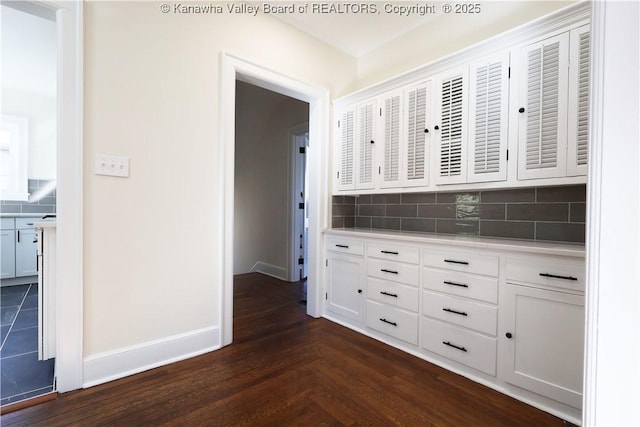 hallway with parquet floors and baseboards