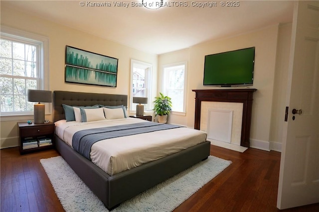 bedroom with dark wood-type flooring and baseboards