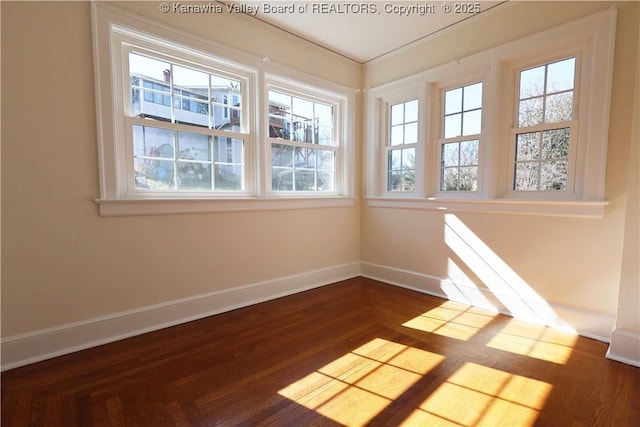 spare room with dark wood-style floors and baseboards