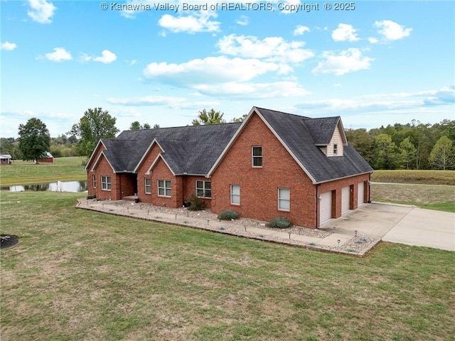 view of front facade with a garage, brick siding, a water view, concrete driveway, and a front lawn