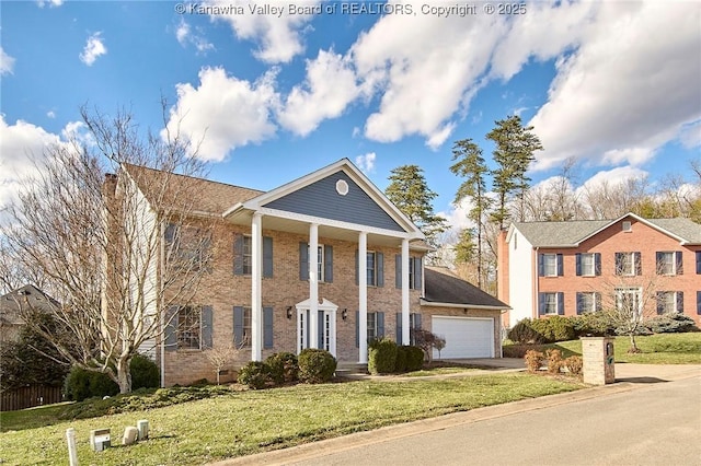 greek revival inspired property with a garage, a front lawn, concrete driveway, and brick siding