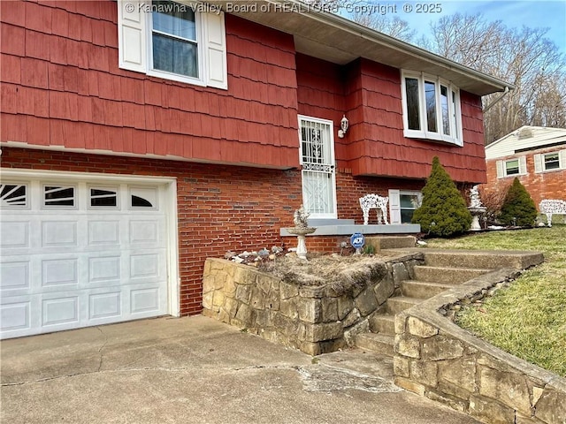 view of front of house featuring a garage, concrete driveway, brick siding, and mansard roof