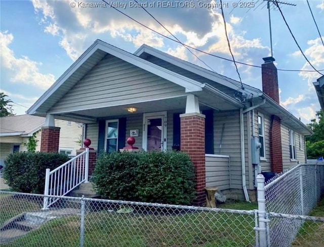 bungalow featuring covered porch, a chimney, and fence private yard