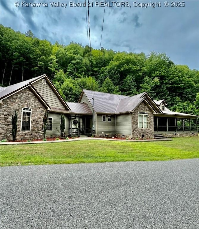 view of front of home with crawl space, stone siding, metal roof, and a front lawn