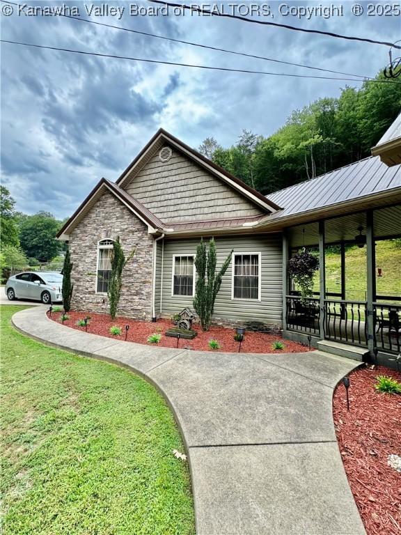 ranch-style house featuring a porch, stone siding, and a front lawn