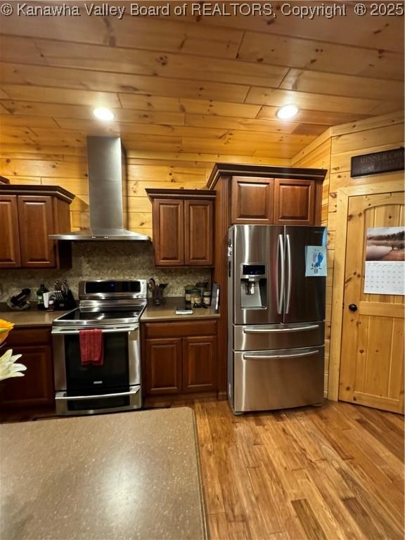 2299 Striker Fork Rd, Chapmanville, WV 25508 - kitchen featuring tasteful backsplash, light wood-style floors, stainless steel appliances, and exhaust hood
