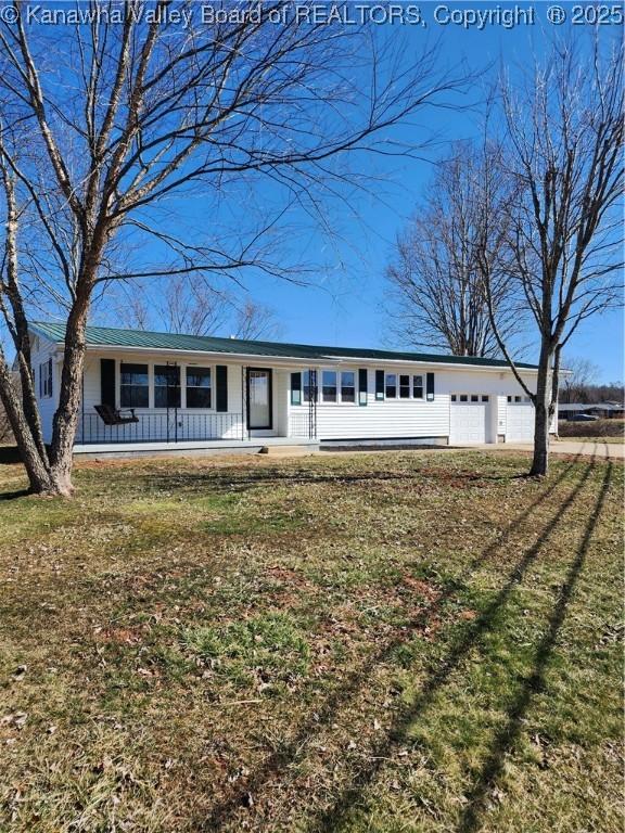 ranch-style house with covered porch, a front yard, and an attached garage