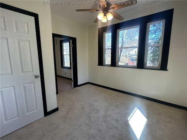 unfurnished room featuring carpet and baseboards