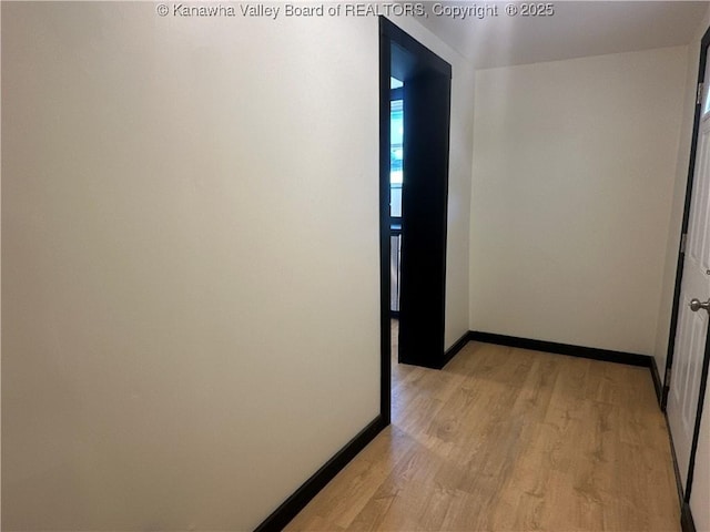 hall featuring light wood-type flooring and baseboards