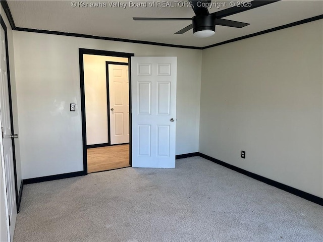 unfurnished bedroom featuring a ceiling fan, carpet, crown molding, and baseboards