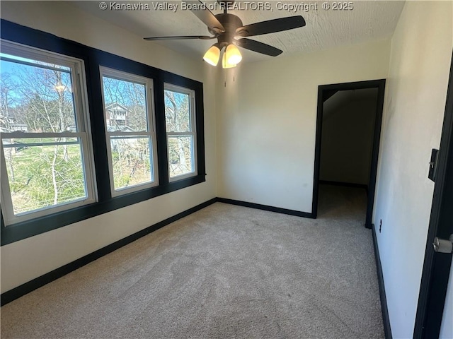 carpeted empty room featuring a textured ceiling and baseboards