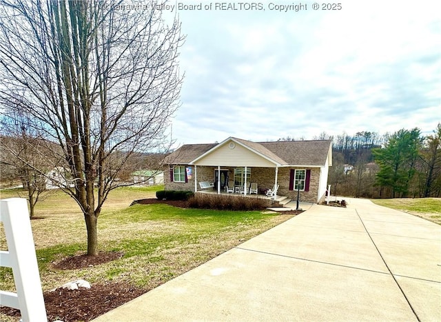 view of front facade featuring concrete driveway, a porch, a front lawn, and brick siding