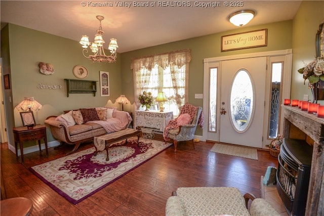 living area with wood-type flooring, baseboards, and an inviting chandelier