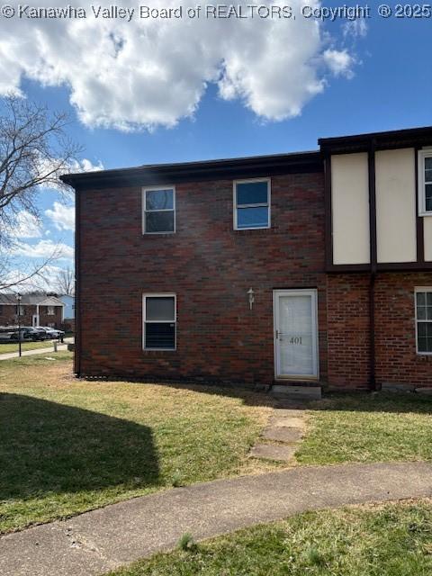 exterior space with a front lawn and brick siding