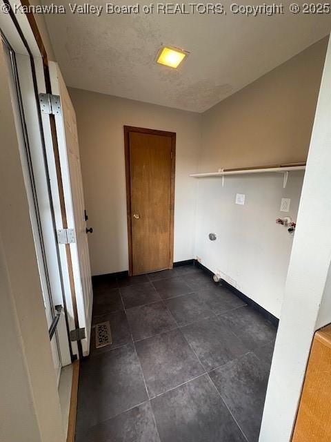 washroom with a textured ceiling and baseboards