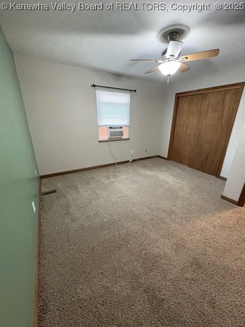 unfurnished bedroom featuring ceiling fan, cooling unit, carpet floors, baseboards, and a closet