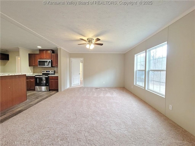 unfurnished living room featuring a textured ceiling, crown molding, a ceiling fan, and light colored carpet