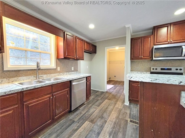 kitchen featuring stainless steel appliances, dark wood-style flooring, a sink, and backsplash