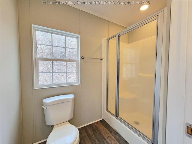 full bathroom featuring a stall shower, wood finished floors, and toilet