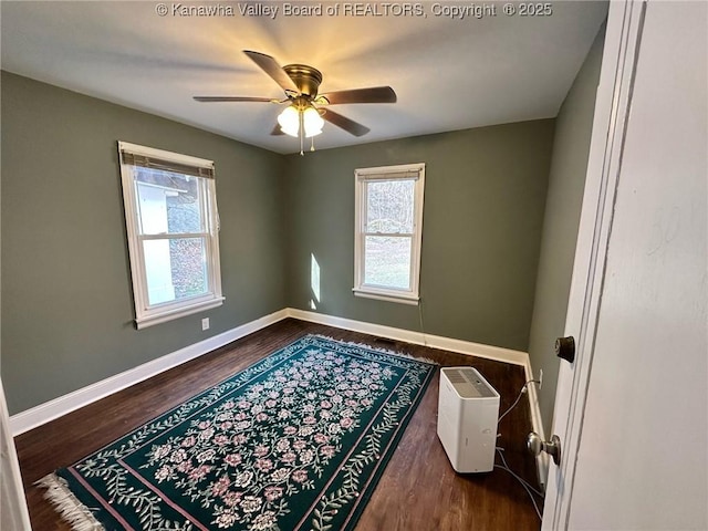 spare room with ceiling fan, wood finished floors, and baseboards