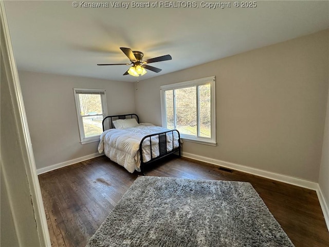 bedroom featuring ceiling fan, baseboards, and dark wood-type flooring