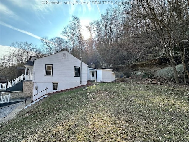 view of side of home with a yard