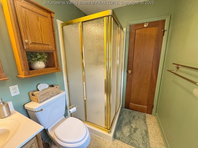 bathroom featuring toilet, tile patterned flooring, a shower stall, and vanity