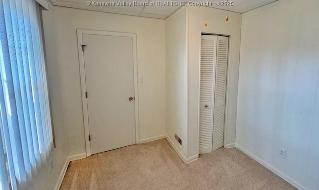 unfurnished bedroom featuring a closet, light carpet, visible vents, and baseboards