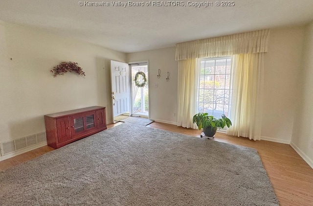 entrance foyer with visible vents, baseboards, and wood finished floors