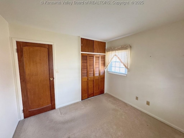 unfurnished bedroom featuring carpet floors, a closet, and baseboards