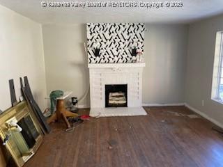 unfurnished living room featuring a large fireplace and wood finished floors