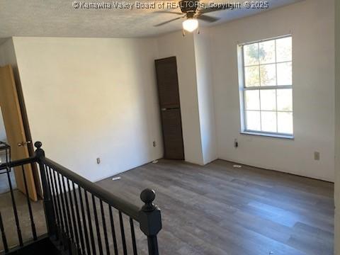 empty room with ceiling fan and wood finished floors