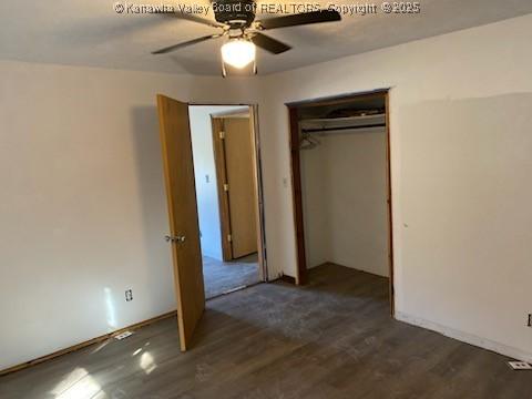 unfurnished bedroom featuring dark wood-style flooring, a closet, and a ceiling fan