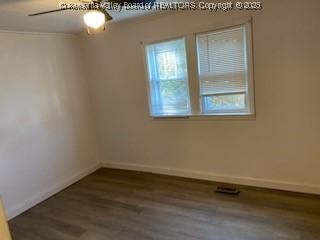 spare room featuring wood finished floors and baseboards