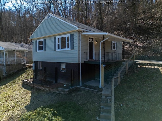 view of front of house with covered porch, stairs, and a front yard