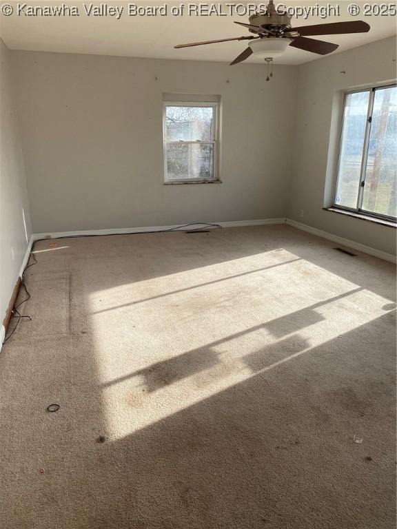 unfurnished room with carpet flooring and baseboards