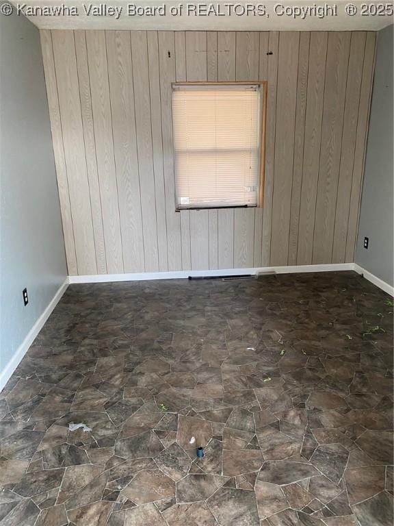 spare room with baseboards