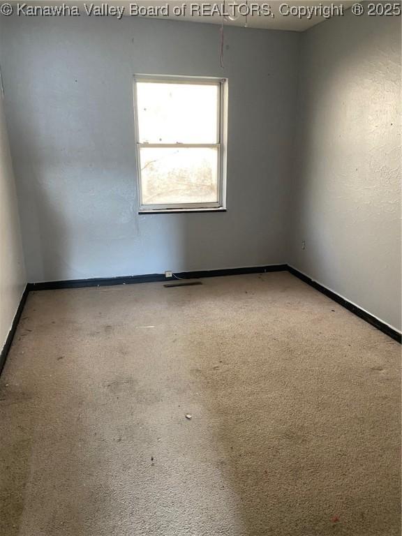 empty room featuring carpet floors and baseboards