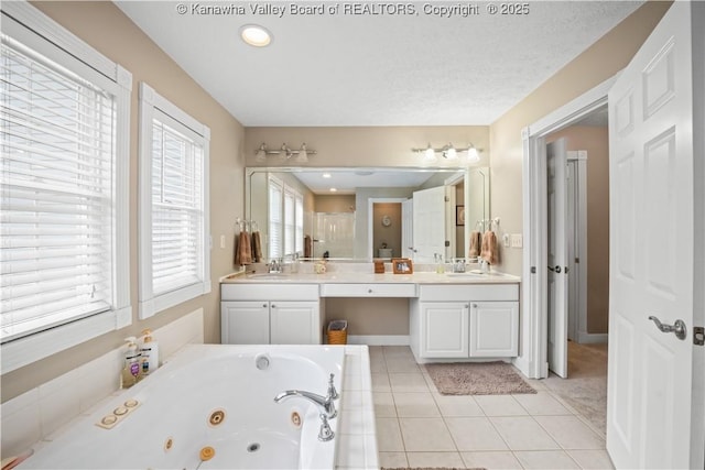 full bath featuring a whirlpool tub, baseboards, vanity, and tile patterned floors