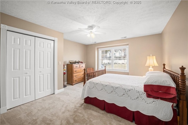 bedroom with a textured ceiling, a closet, carpet flooring, and a ceiling fan