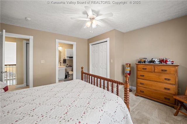 bedroom with baseboards, connected bathroom, light colored carpet, ceiling fan, and a closet