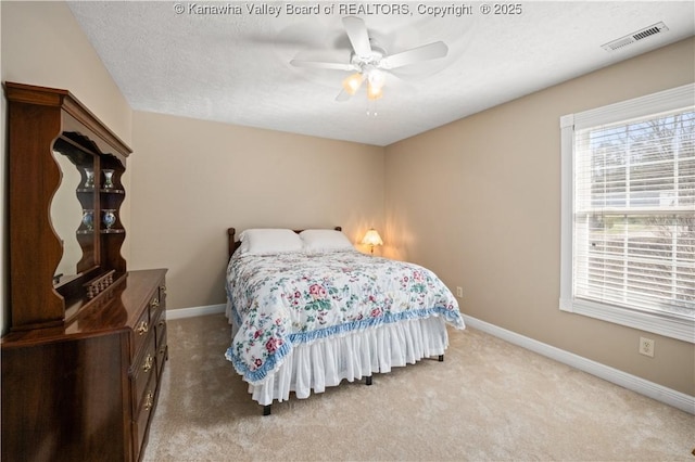 bedroom with baseboards, visible vents, and light colored carpet