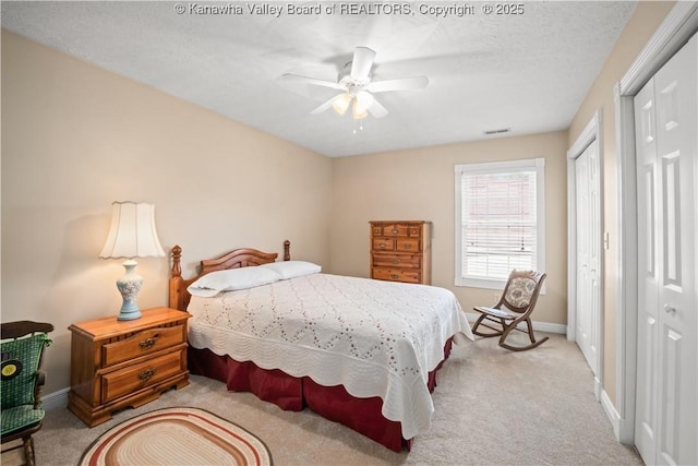 bedroom with baseboards, light colored carpet, and multiple closets