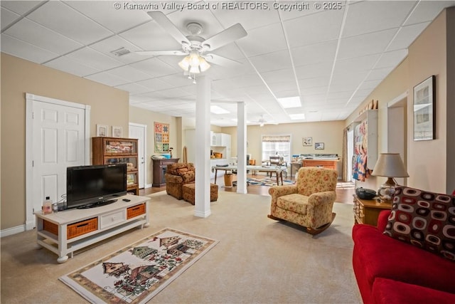 living room featuring visible vents, a ceiling fan, carpet, a paneled ceiling, and ornate columns